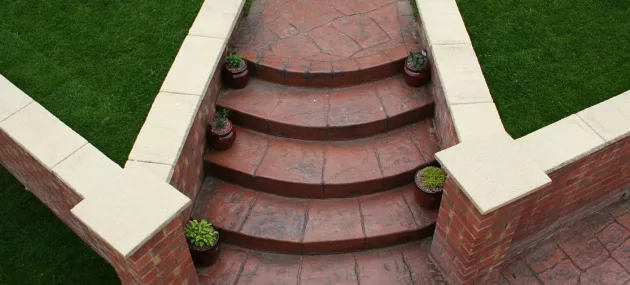 Pattern imprinted concrete steps by PICS with surrounding brickwork and turf. Ideal for decorative pathways.