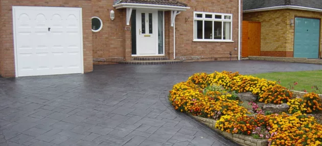 Pattern imprinted concrete driveway by PICS, featuring floral border design.