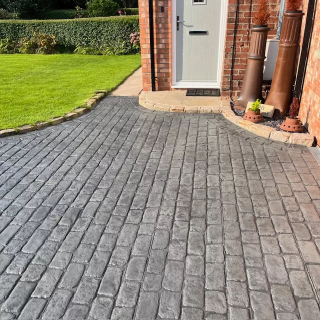 Pattern imprinted concrete driveway by PICS, showcasing textured paving supplies.