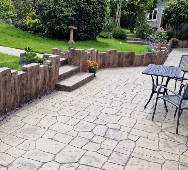 Pattern imprinted concrete patio with fence by PICS, ideal for outdoor spaces and landscaping.